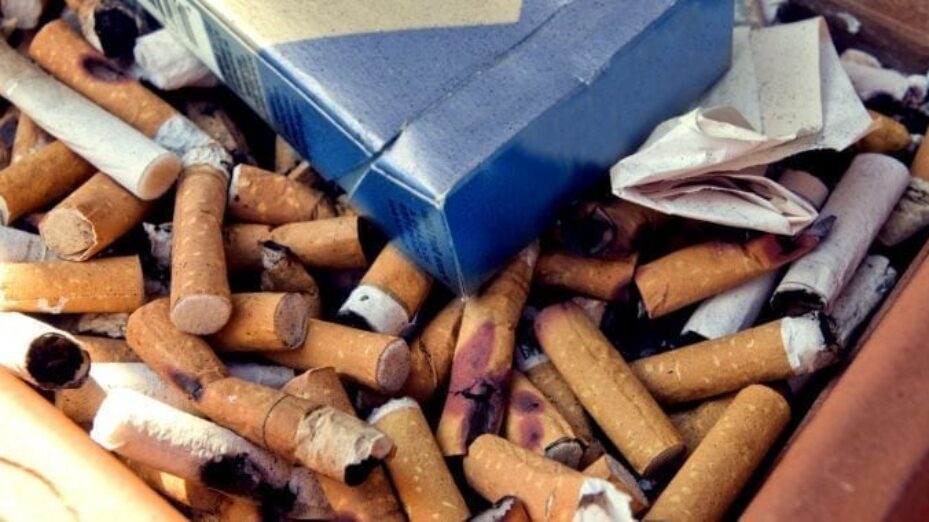 ashtray-filled-with-used-cigarette-butts-along-with-some-empty-cigarette-carton-725x380