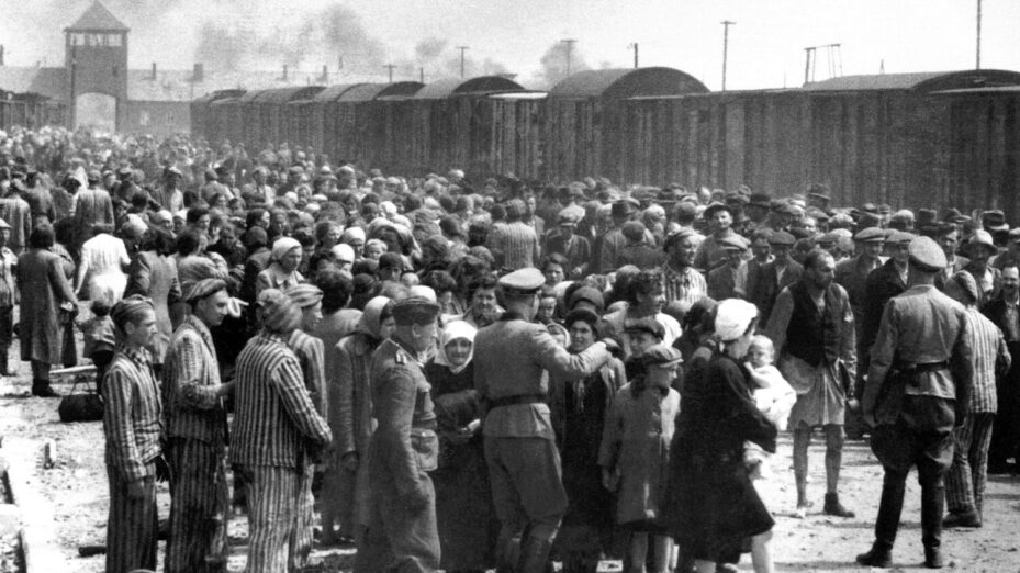 Par Bernhard Walter — Yad Vashem: "Jews undergoing selection on the ramp. Visible in the background is the famous entrance to the camp. Some veteran inmates are helping the new comers.", Domaine public, https://commons.wikimedia.org/w/index.php?curid=39226962